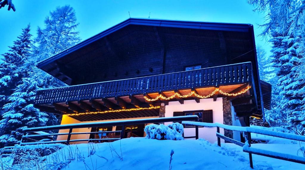 a building covered in snow with trees in the background at Chalet Alpl - Ferienwohnung Waldblick mit Sauna, Kamin & Whirlwanne in Hochrindl