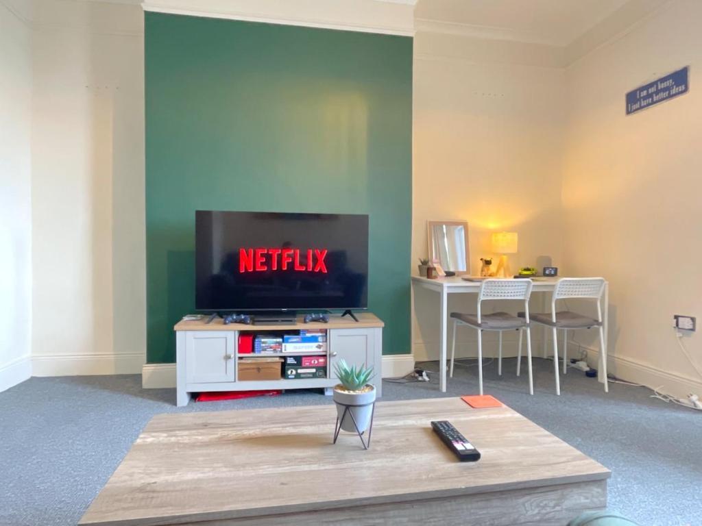 a living room with a flat screen tv and a table at HNFC Stays - Shoreline Flat in South Shields