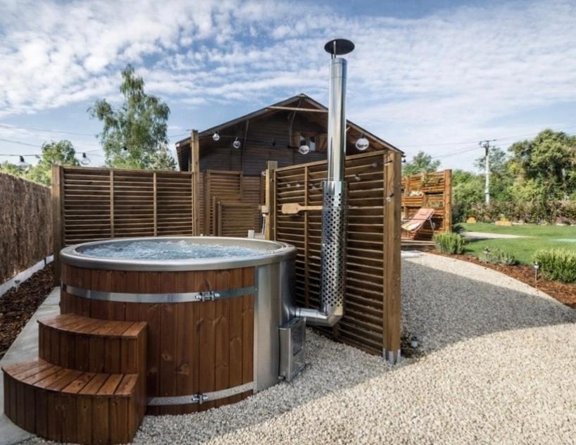 a hot tub in the backyard of a house at L'Écrin - Chalet & Bain Nordique Luxe vue lac in Prouilly