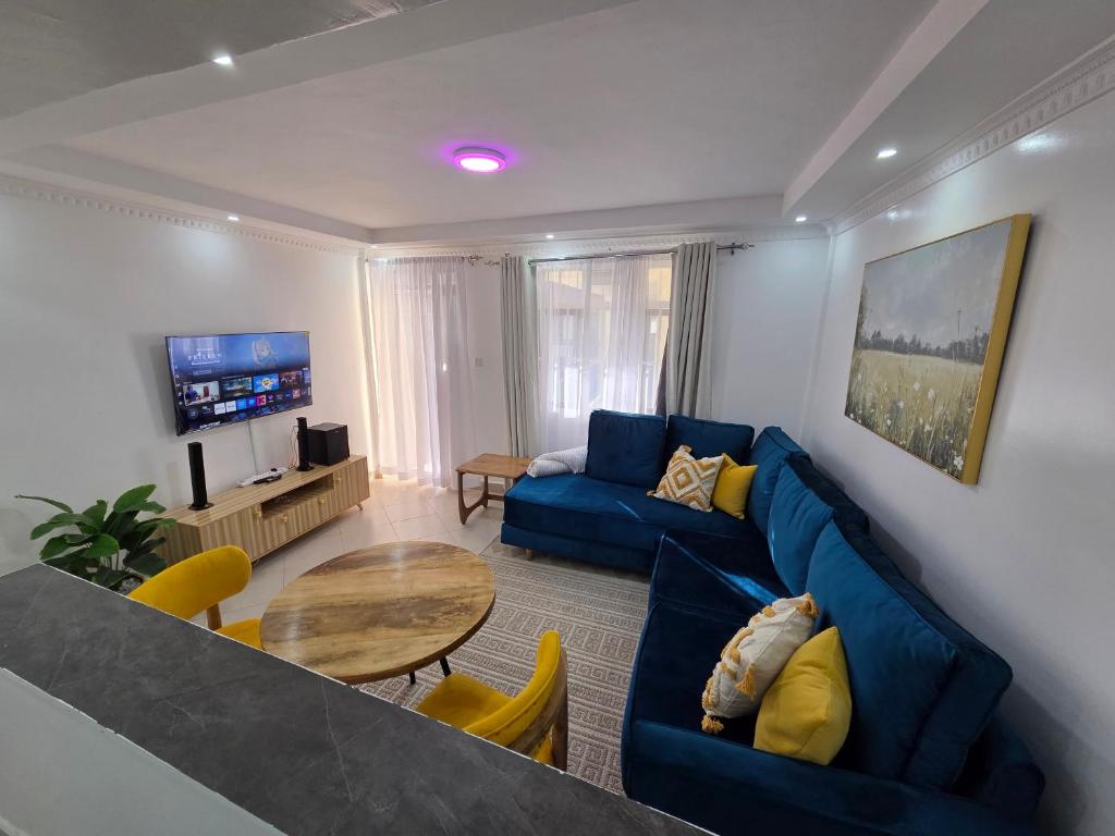a living room with a blue couch and a table at Waridi Homes-2 BR Naivegas Apartments, Naivasha in Munyu