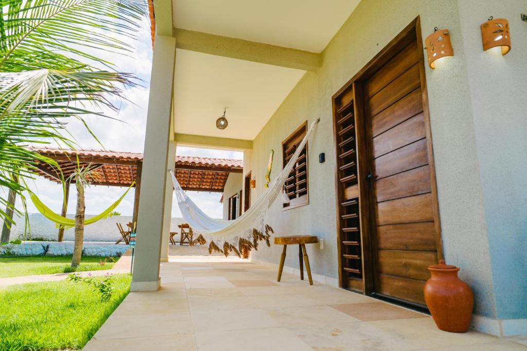 a door to a house with a view of the ocean at Chalé sol de Macapá 1- Refúgio Pertinho do Mar in Luis Correia