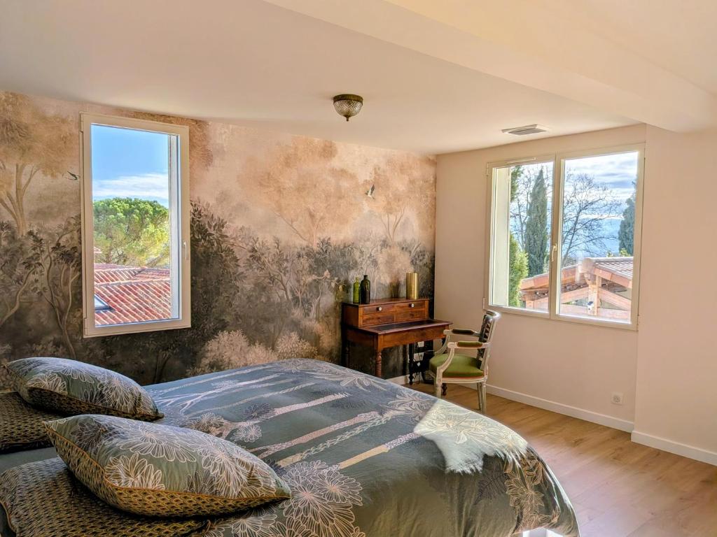 a bedroom with a bed and a desk and windows at Domaine de Grave in Mirepoix