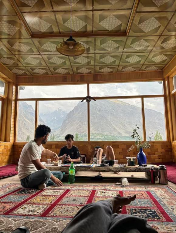 a group of people sitting in a room with a large window at verse hunza in Karimabad Hunza