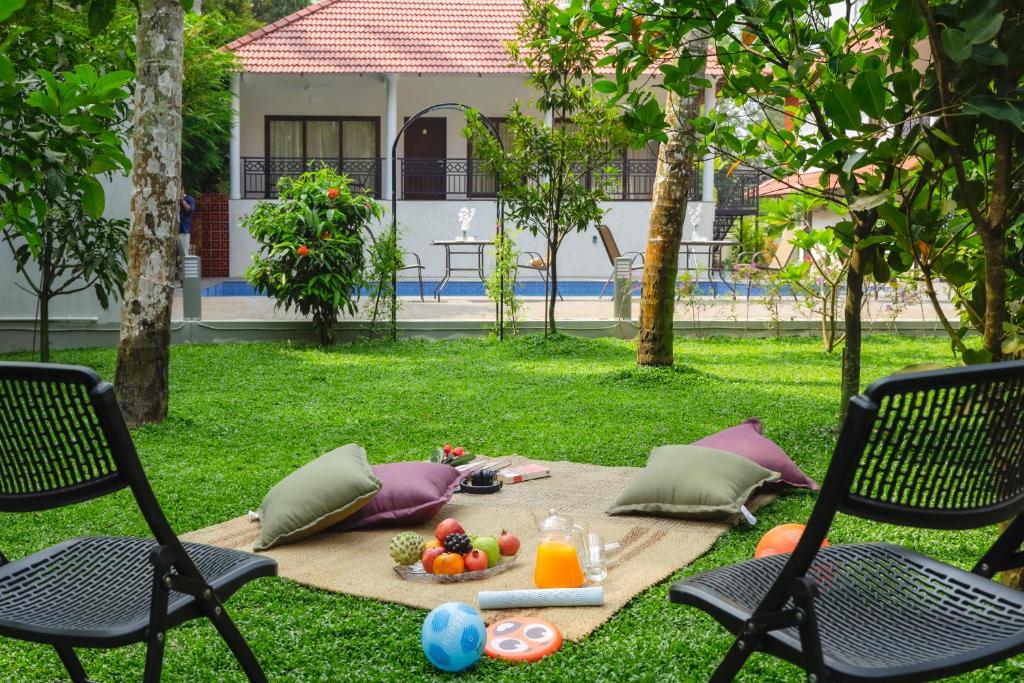 a picnic set up on the grass with two chairs at River Whisper Villa in Cochin