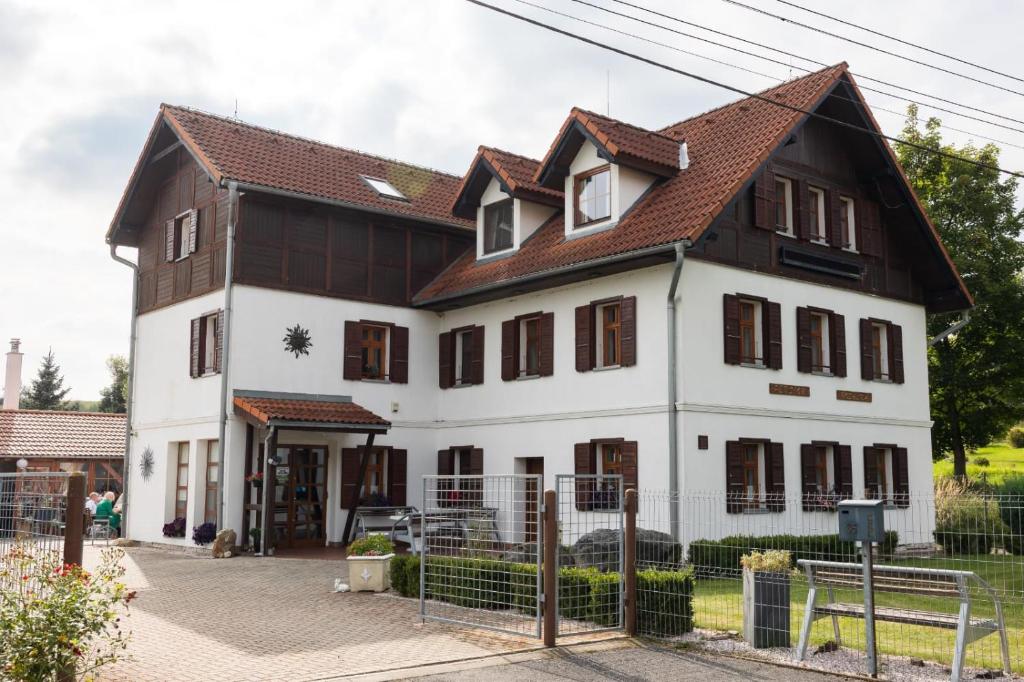 a large white house with a brown roof at Apartmány Rosalka in Stará Oleška