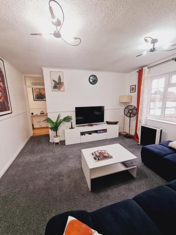 a living room with a couch and a coffee table at Elisha's City Apartment in Hackbridge