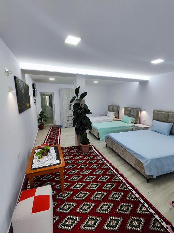 a bedroom with two beds and a rug at Sokaku Apartment in Gjirokastër