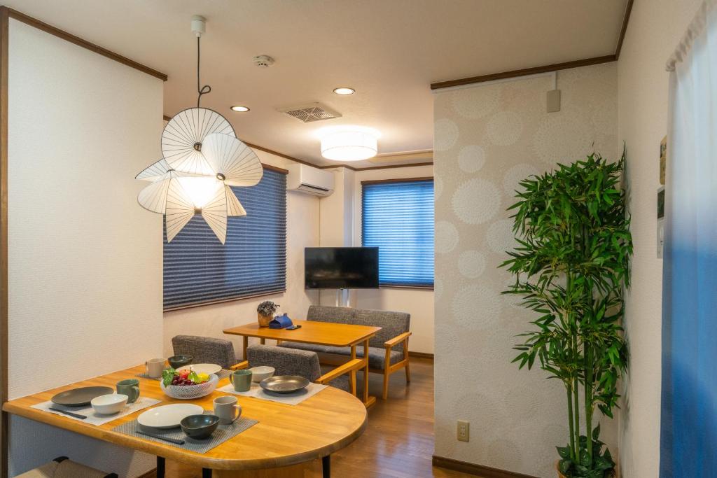a living room with a table and a dining room at Guest Houseふくふく in Shimonoseki