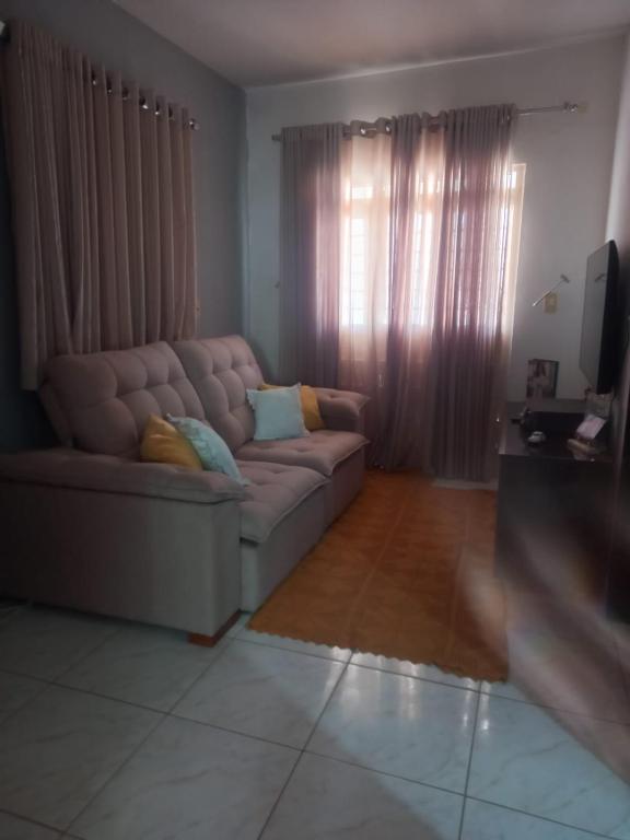 a living room with a couch and a television at Casa Conforto e Aconchego com garagem e internet próximo ao centro in Pesqueira