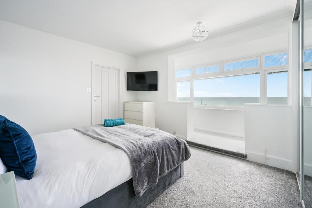 a white bedroom with a bed and a television at Ocean View in Worthing, 5 bedrooms for 10, 3 Bathrooms, Hot Tub, Parking for 6, Seaview in Sompting