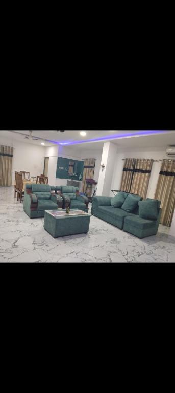a large living room with green couches and a table at Panahh in Guwahati