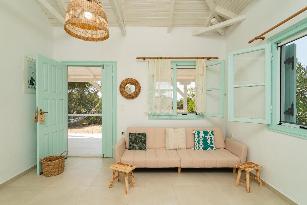 a living room with a couch and windows at Varka Bungalows in Methoni