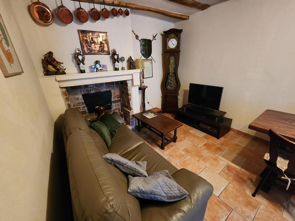 a living room with a couch and a fireplace at La maison bleue in Velet