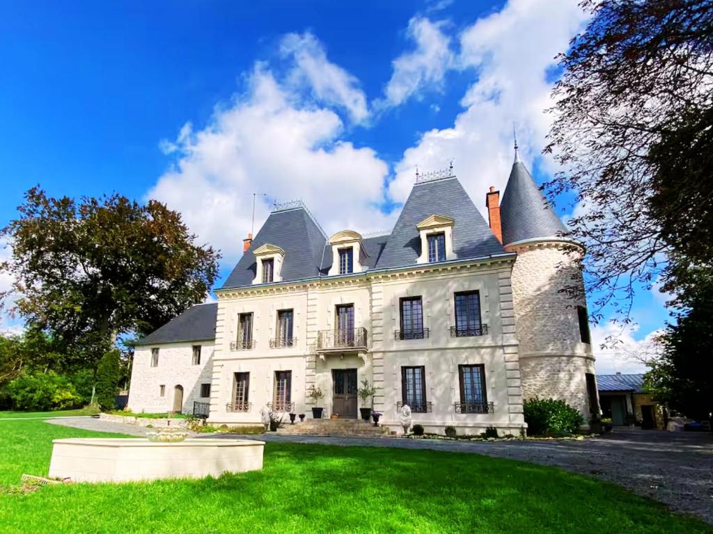 a large white house with a turret at Château des Bourdons Charme, Spa & Nature in Varennes Vauzelles