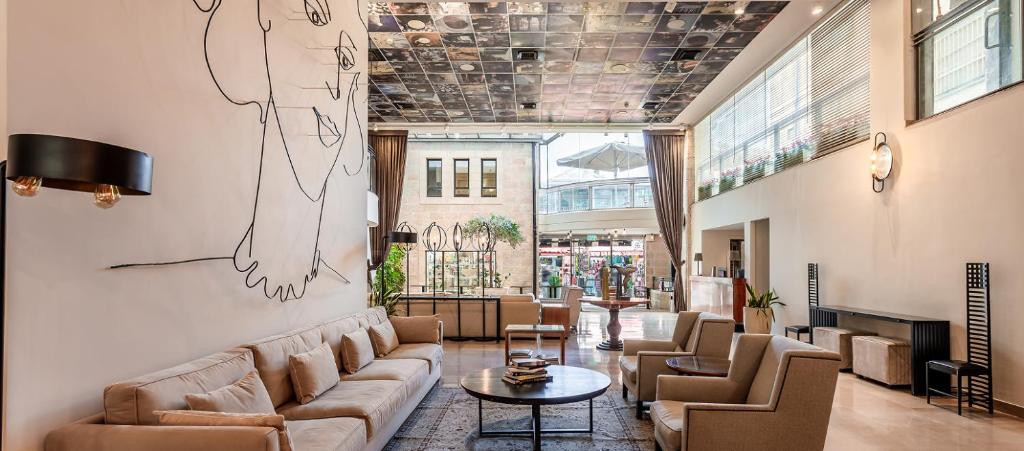 a lobby with a couch and chairs and a table at Jacob Harmony in Jerusalem