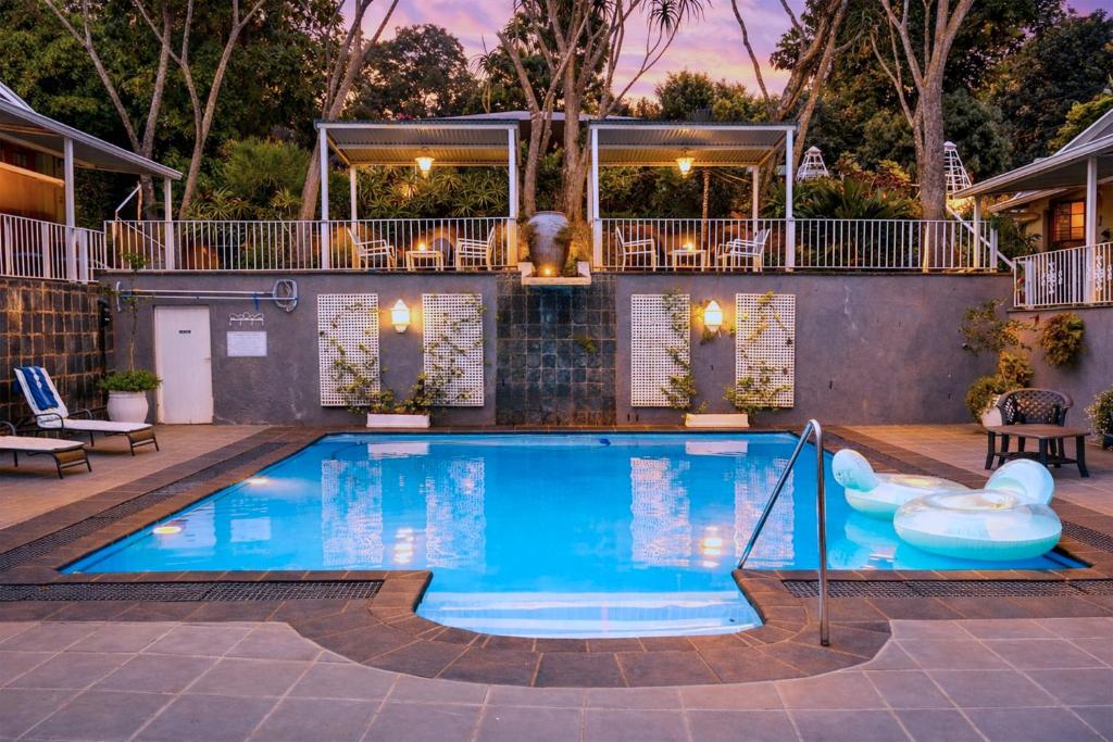 a swimming pool in a backyard with a house at Apartment 7 On Oakleigh in Pietermaritzburg