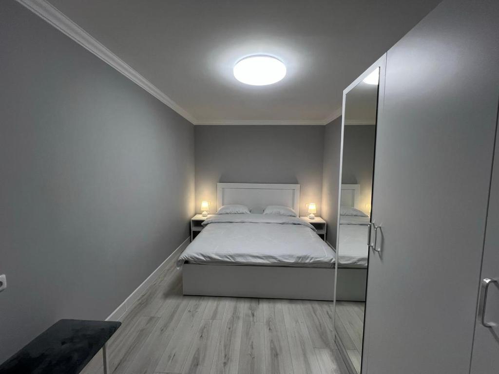 a small bedroom with a bed and a mirror at Hotel in Yerevan in Yerevan