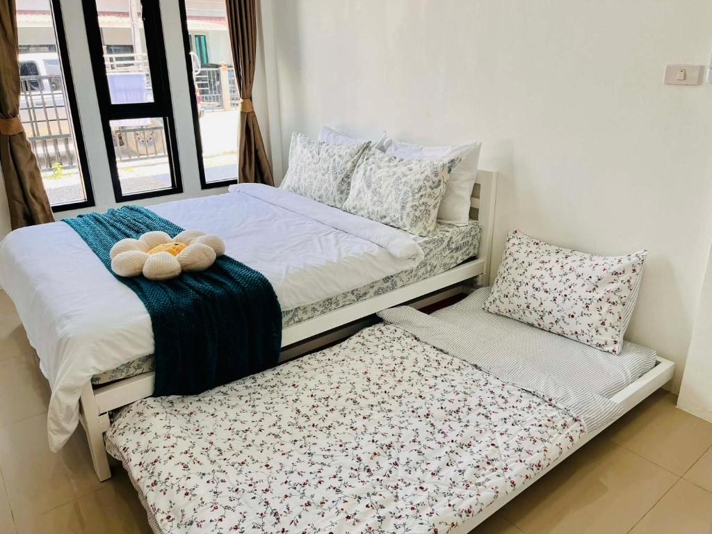 two stuffed animals sitting on a bed in a room at Comfort Home stay Private Room A Shared House in Ban Tha Khun