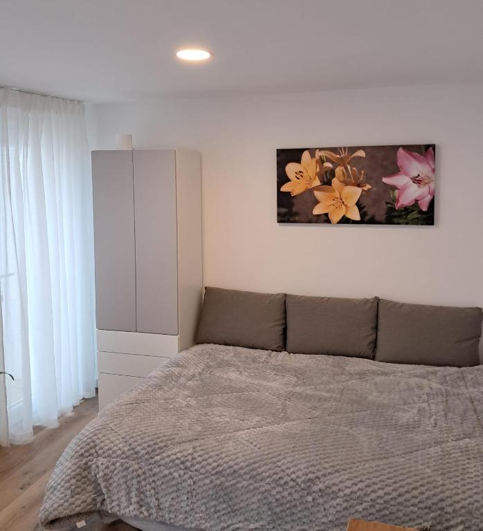 a bedroom with a bed and a painting on the wall at Hikary in Lavra