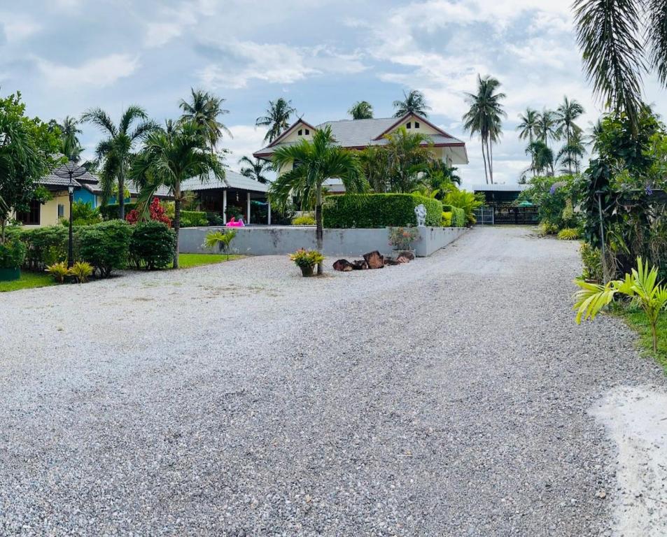 a gravel driveway in front of a house at Apple Bungalows in Bang Saphan