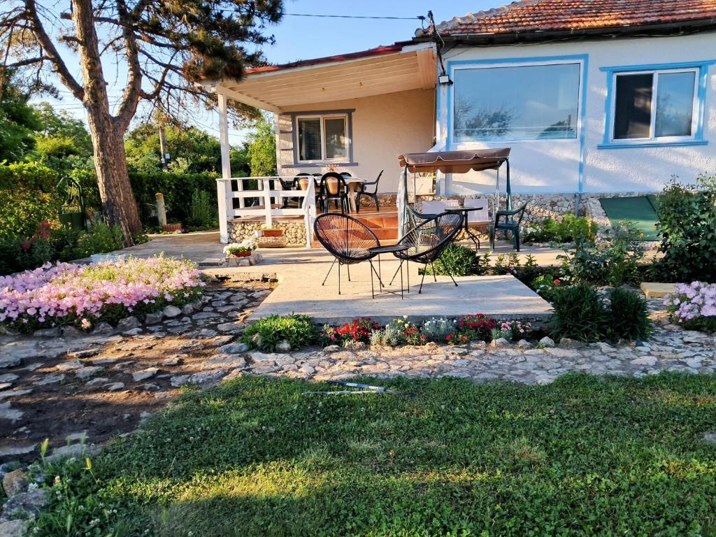 a garden with chairs and a table and a house at Vila 'Anna' in Krapets