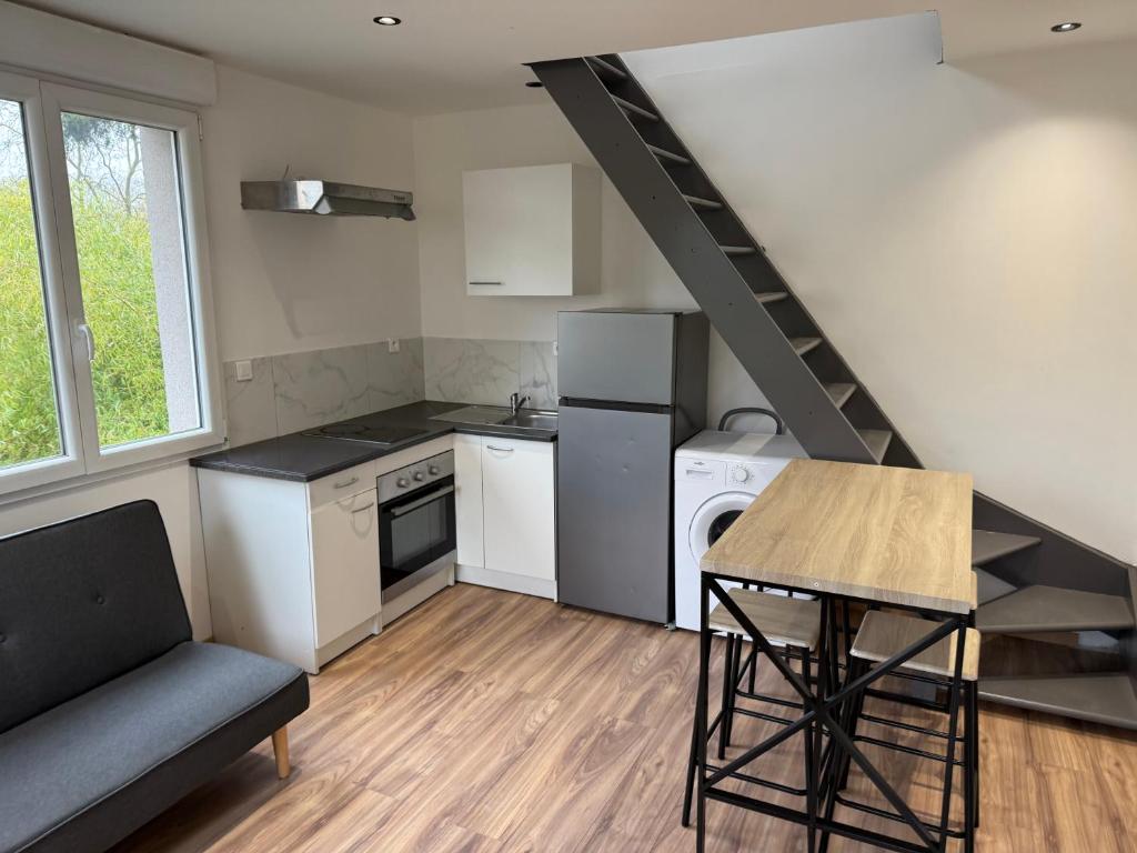 a small kitchen with a staircase and a table at Jolie duplex face à la Seine in Villeneuve-le-Roi