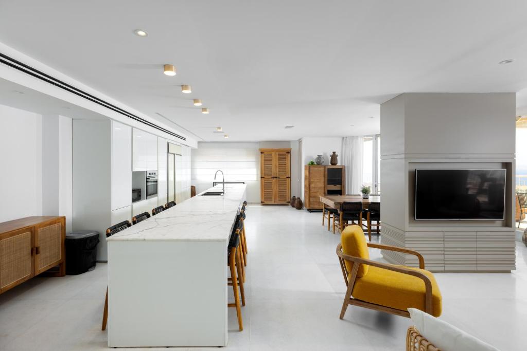 a kitchen and living room with a counter and a tv at Kedem Eilat קדם אילת in Eilat