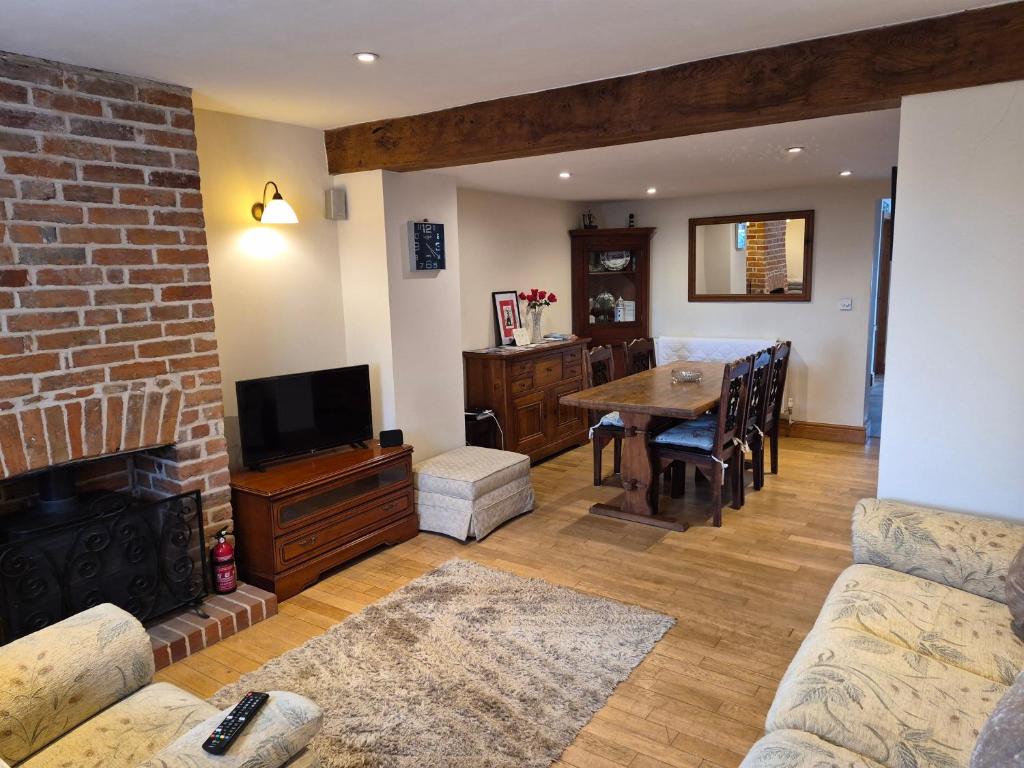 a living room with a fireplace and a dining room at Coastline cottage Pakefield, 2 minutes walk to the beach in Pakefield