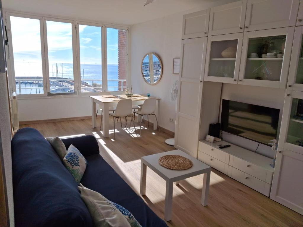 a living room with a blue couch and a table at Candela's Beach Port in El Masnou