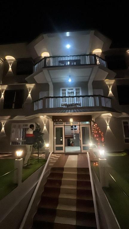 a house with a staircase leading to the front door at night at Hotel Sunrise in Sāmthar