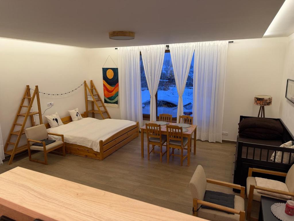 a bedroom with a bed and a table and chairs at Dům mezi loukami in Sněžné