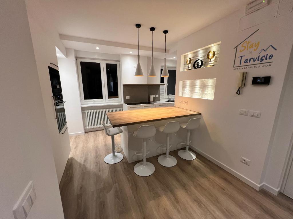 a kitchen with a table and stools in a room at MARY Apartment in Tarvisio