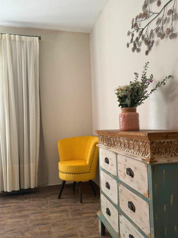a yellow chair and a dresser in a room at Las Cabras Complejo Turístico in Potrero de los Funes