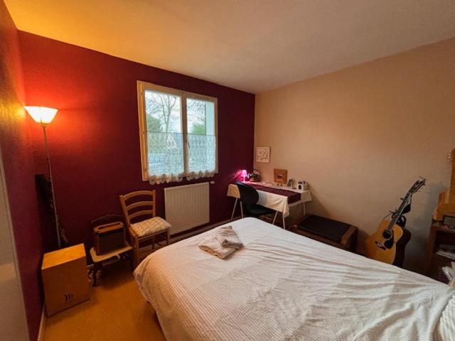 a bedroom with a bed and a desk and a window at Chambre lit double in Saint-Herblain