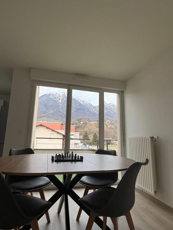 a room with a table and chairs and a window at Appartement T2 Confort in Albertville
