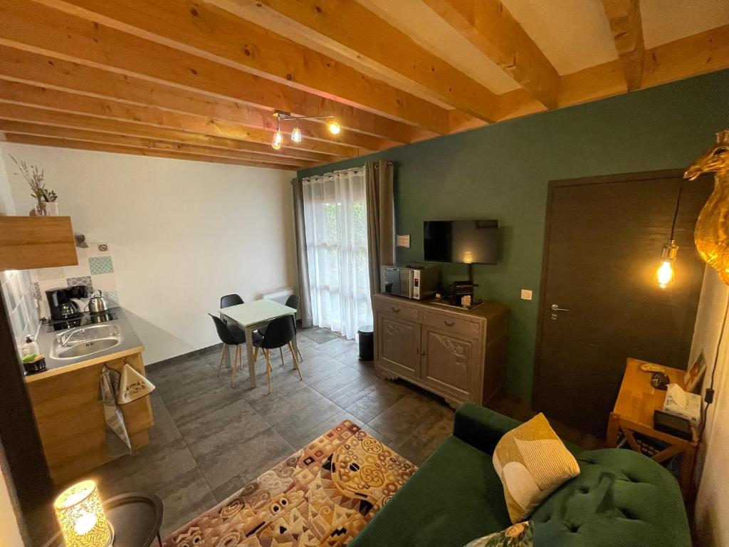 a living room with a couch and a table and a kitchen at Appartement Plein Pied Arrow Wood La Flèche in La Flèche