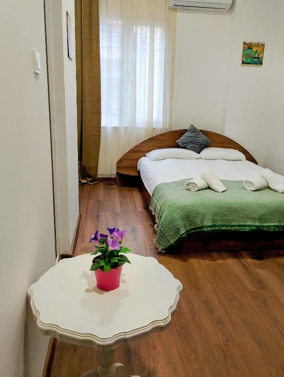 a room with two beds and a table with flowers on it at GuestHouse3 Karma369 in Plovdiv