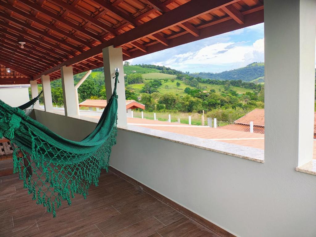 a hammock on the balcony of a house with a view at Casas Bela Vista 1 - 2 in Águas de Lindoia