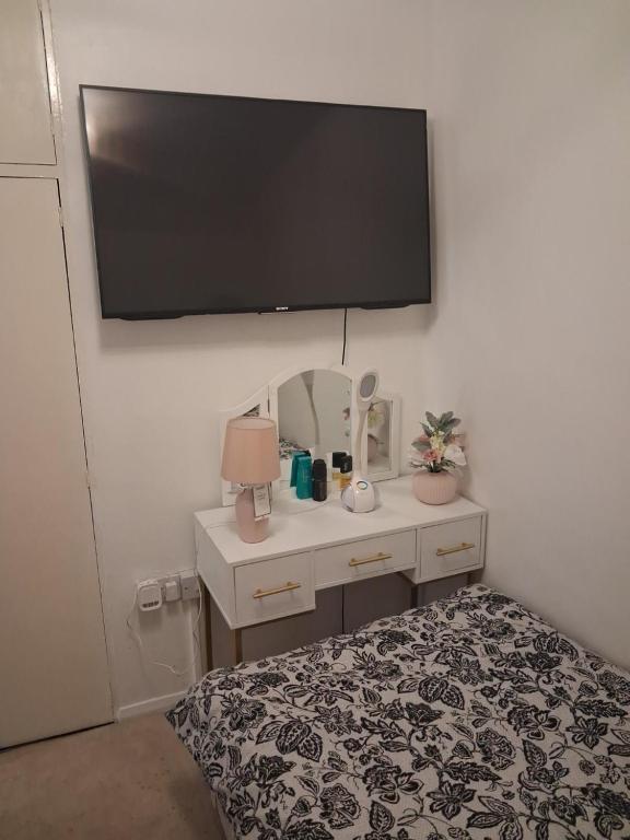 a bedroom with a bed and a tv on the wall at Cullen Sqaure in South Ockendon