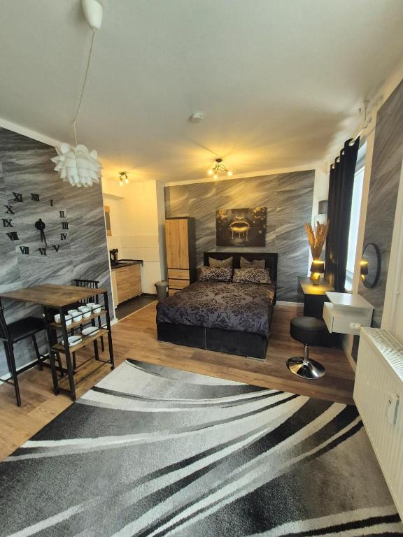 a bedroom with a bed and a desk and a table at Onyx Urban Suite in Hannover