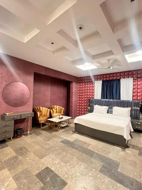 a bedroom with a bed and a living room at Royal Confort Inn in Karachi