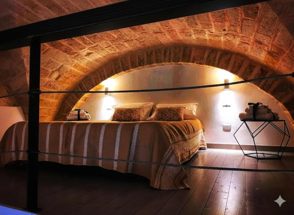 a bedroom with a bed in a brick wall at Amalò Guest House in Bari