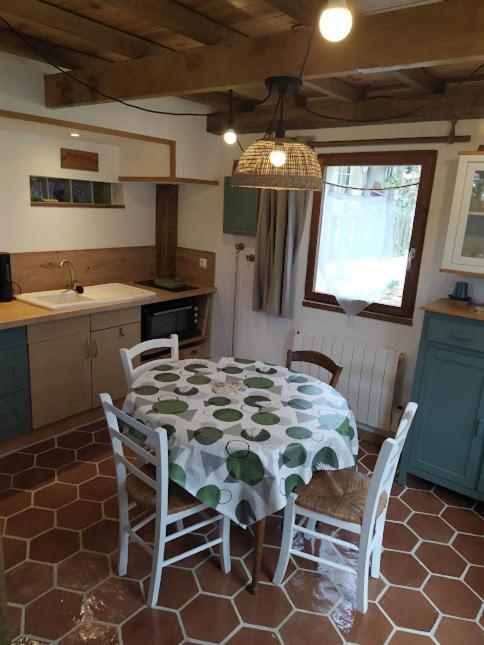 a kitchen with a table and chairs in a kitchen at Le refuge in Montabon