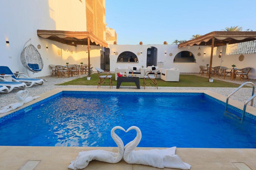 a swimming pool with two swans in the water at White Gorf Hotel in Luxor