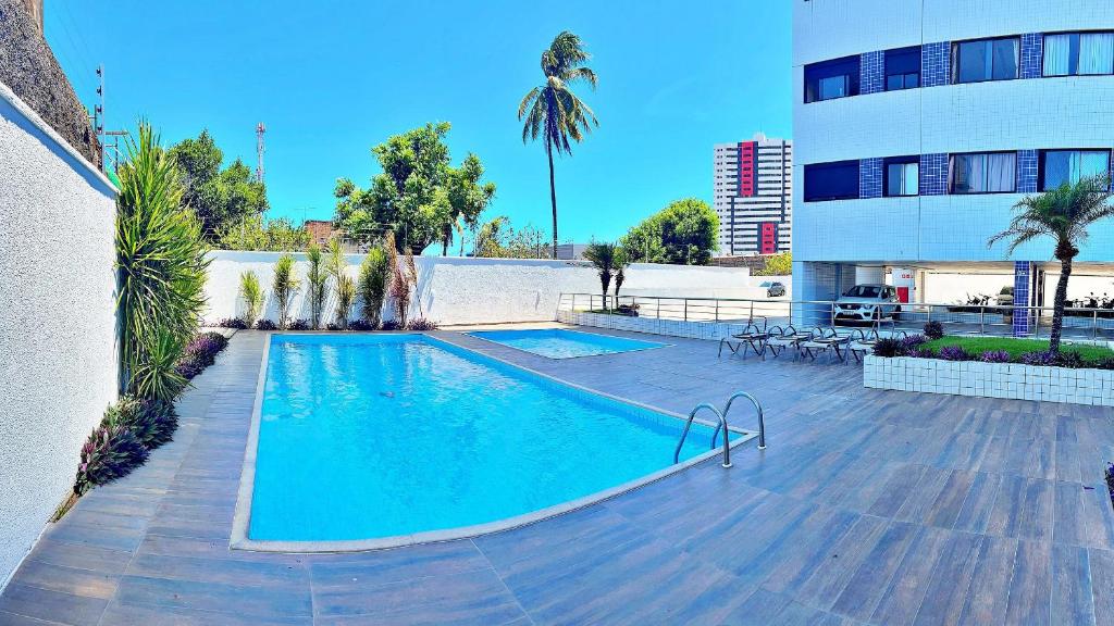 a swimming pool in front of a building at Vacanze - Alicante in Maceió