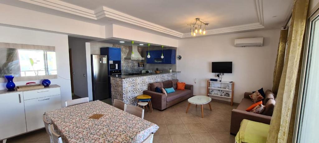 a kitchen and living room with a couch and a table at Excellent Appartement S plus 3 in Kelibia