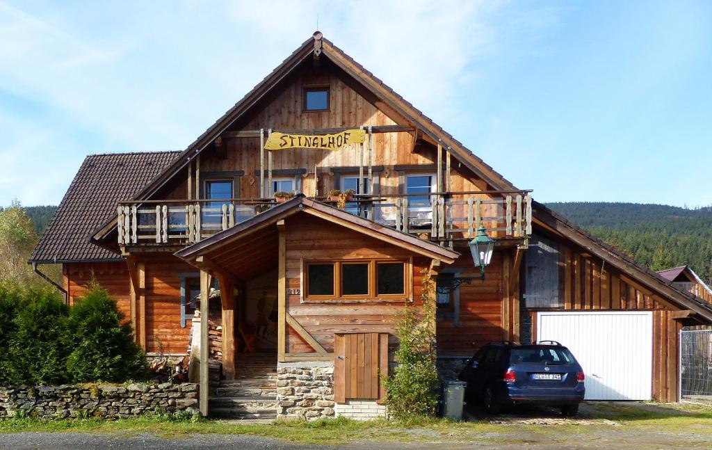 a log cabin with a car parked in front of it at Stinglhof in Železná Ruda