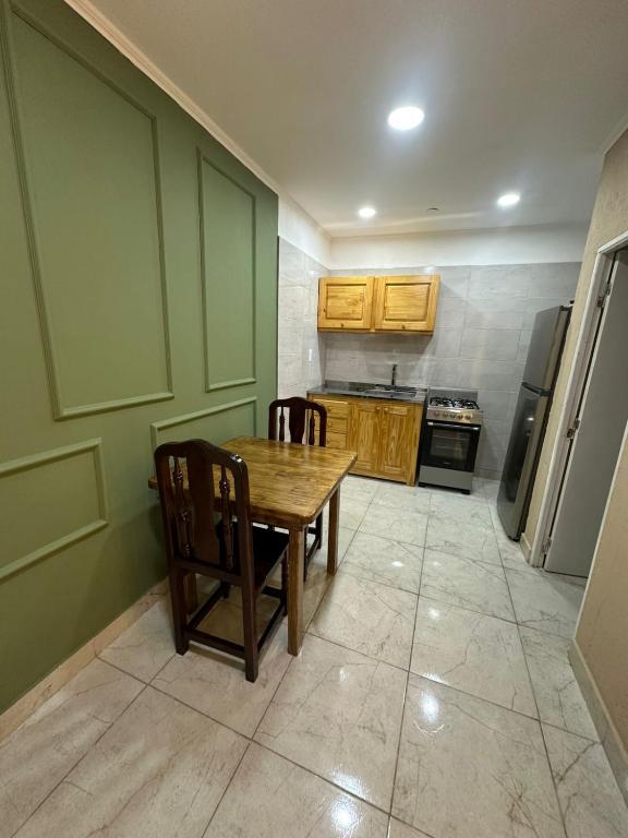 a small kitchen with a wooden table and chairs at Deptos Helen in Termas de Río Hondo