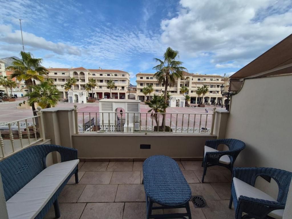 a balcony with chairs and a view of a building at Apartamento Escobar Plaza in Nerja
