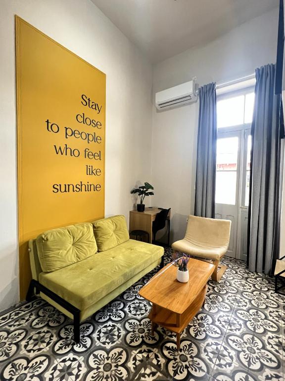ein Wohnzimmer mit einer grünen Couch und einem Tisch in der Unterkunft Apartment Studio 5 in Mytilini